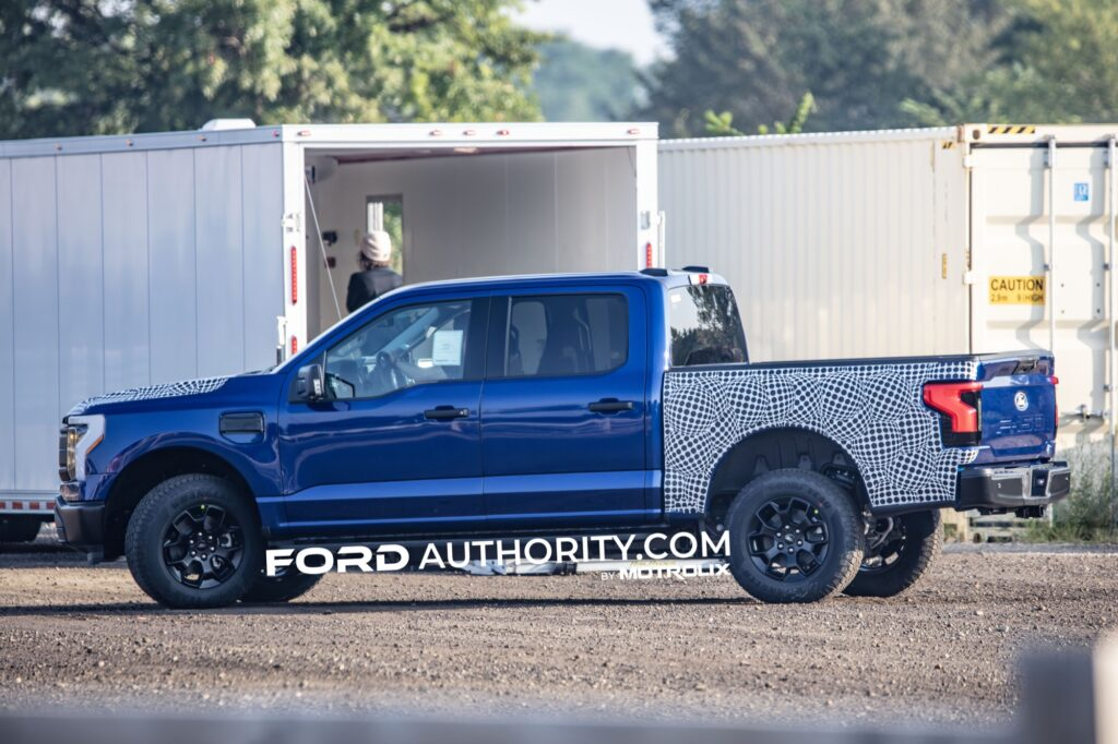 Alt Text: Ford F-150 Lightning Tremor prototype testing with partial camouflage on hood and sides, spotted on public road.